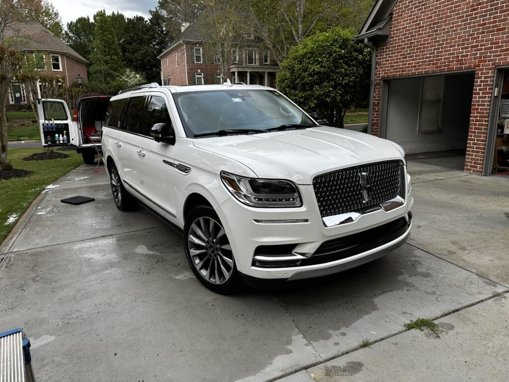 White Lincoln Navigator after a full mobile detail in a driveway